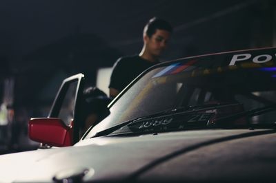 Midsection of man standing in car