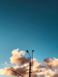 Low angle view of street light against blue sky