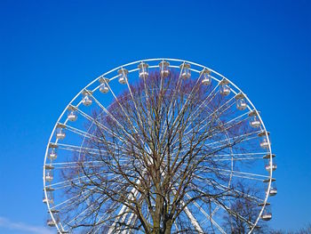 Low angle view of ferris wheel against clear blue sky