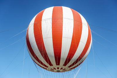 Low angle view of hot air balloons against clear blue sky