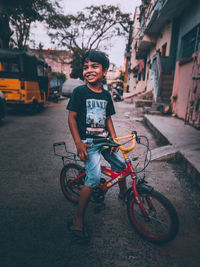 Full length of smiling boy on street in city