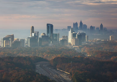 Aerial view of buildings in city against sky at sunset