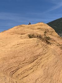 Man on arid landscape against sky