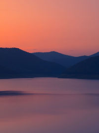 Scenic view of silhouette mountains against romantic sky at sunset