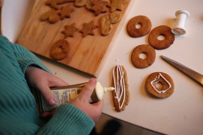 Midsection of girl decorating gingerbread cookies at table