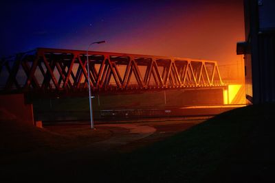 Illuminated bridge against sky at night