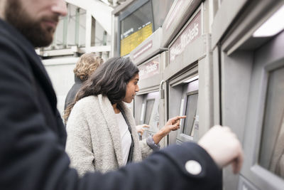 People buying tickets at ticket vending machines