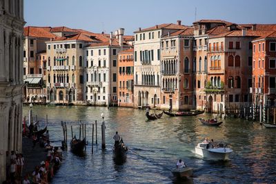 Boats in water against buildings