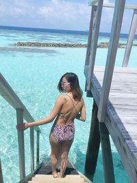 Full length portrait of young woman standing in sea