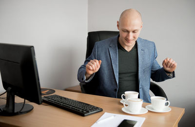 Businessman having coffee at desk in office