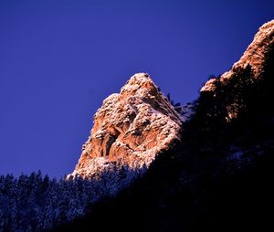 Low angle view of rocky mountains against clear sky