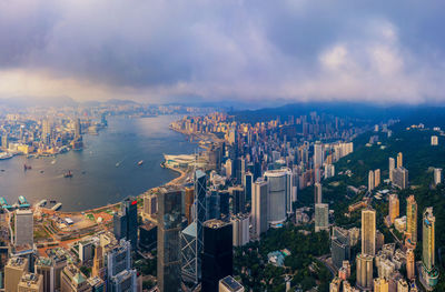 High angle view of city buildings against cloudy sky