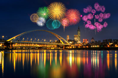 Firework display over river at night