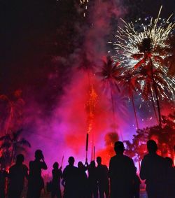 Low angle view of silhouette people against sky at night