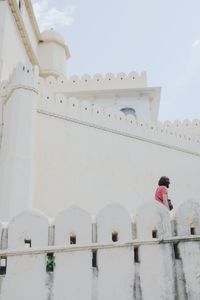 Low angle view of man by white building