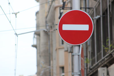 Low angle view of do not enter sign against building