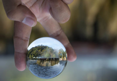 Close-up of hand holding crystal ball