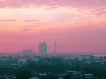 Aerial view of buildings in city during sunset