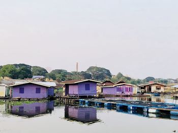 Houses by lake against sky