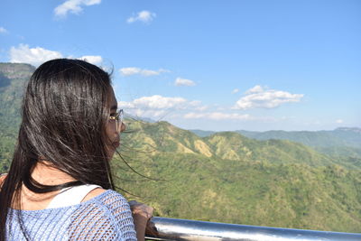 Woman looking at mountains against sky