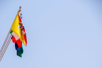 Low angle view of flag against clear blue sky