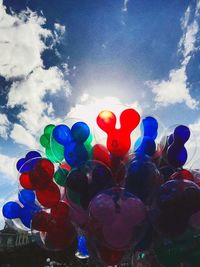 Low angle view of multi colored balloons against sky