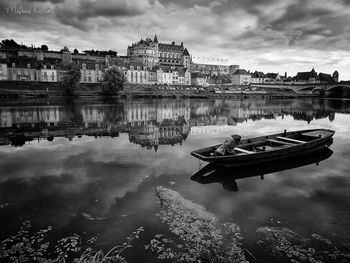 Reflection of buildings in river against sky