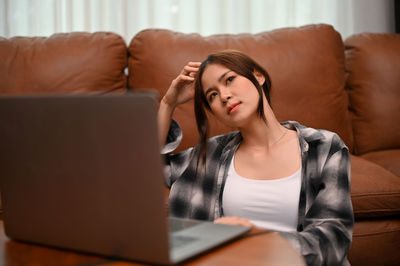 Young woman using laptop at home