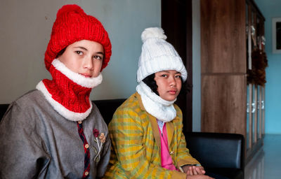 Two young women stand near the window and look aside, a quiet and gloomy day.