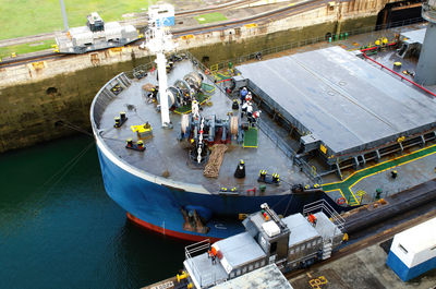 Tankship prow detail with crew at work, entering the canal locks of miraflores in the panama canal