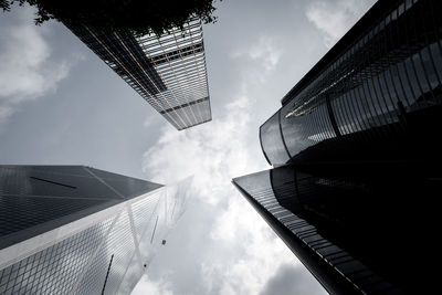 Low angle view of skyscrapers against cloudy sky