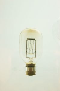 Close-up of light bulb against wall