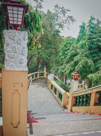 Text on railing against trees in city