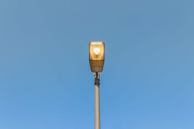 Low angle view of street light against clear blue sky