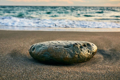 Close-up of pebbles on sand at beach