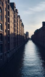 Canal amidst buildings against sky in city in hamburg