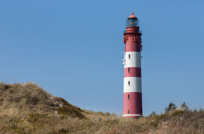 Low angle view of lighthouse against clear blue sky