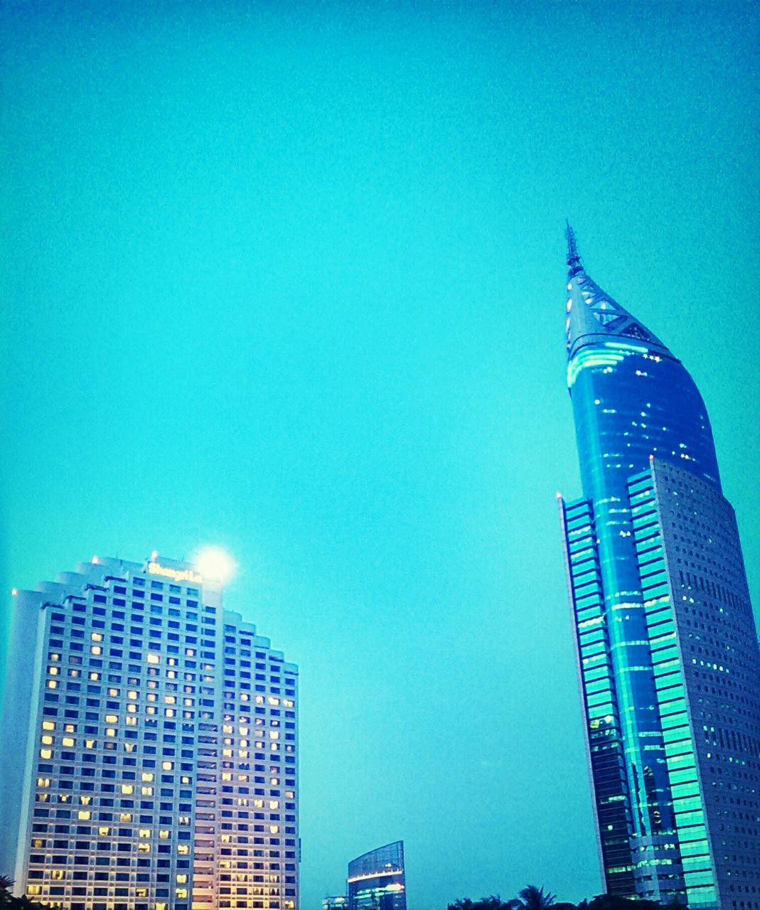 building exterior, architecture, built structure, low angle view, blue, clear sky, skyscraper, city, modern, tall - high, office building, tower, copy space, building, glass - material, outdoors, urban skyline, financial district, tall, day