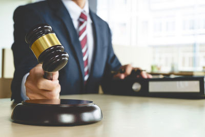 Midsection of man sitting on table