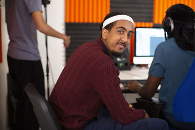 Side view of man sitting in recording studio