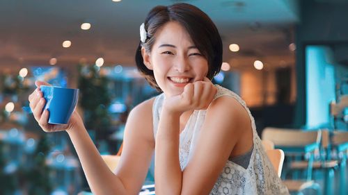 Side view of young woman drinking glass