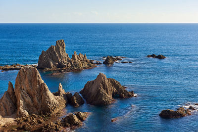 Scenic view of rock formations by sea at cabo de gata-nijar natural park during sunset