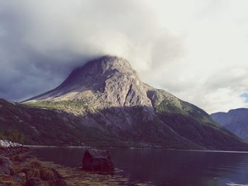 Scenic view of sea and mountains against cloudy sky