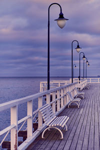 Close-up of street light by sea against sky