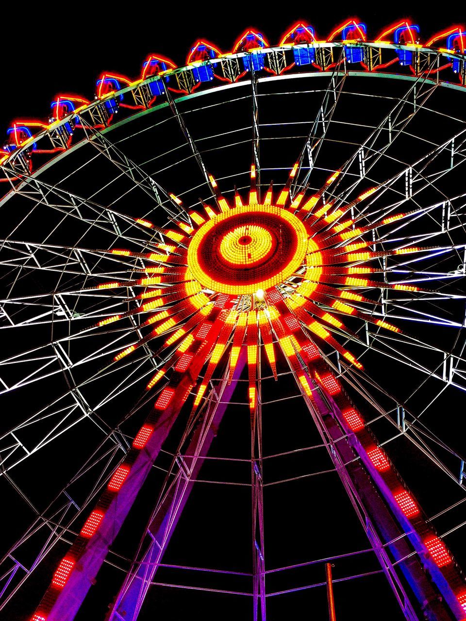 LOW ANGLE VIEW OF ILLUMINATED FERRIS WHEEL AGAINST SKY AT NIGHT