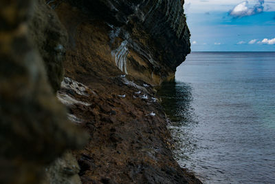 Rock formation on sea against sky