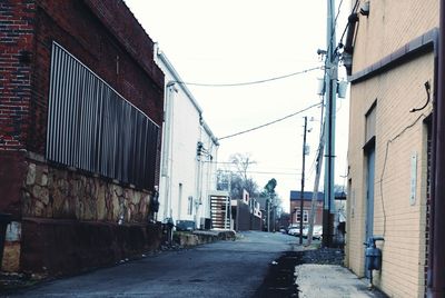 Road amidst buildings in city against sky