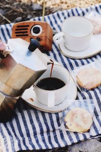 High angle view of coffee cup on picnic blanket