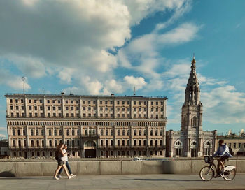 People on street against buildings in city