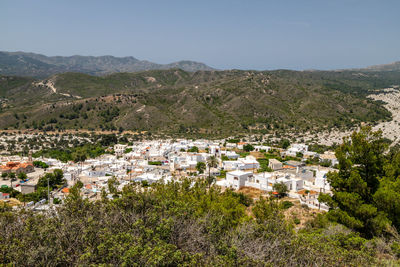 Aerial view of townscape and mountains against sky